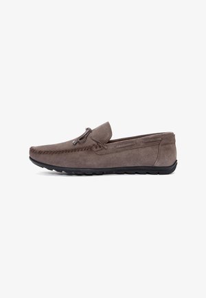 Mocasin de ante con punta redondeada, color gris, costura decorativa, acento de cordones en la parte delantera y suela de goma negra flexible.