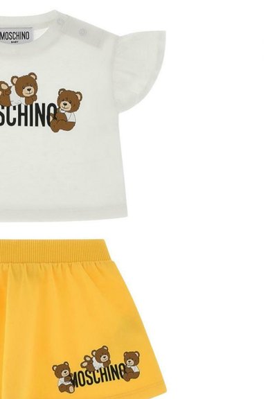 Weißes Kurzarmhemd mit Bären-Grafik und "MOSCHINO"-Text, kombiniert mit einem gelben Rock mit elastischem Bund, der passende Bärendesigns aufweist.