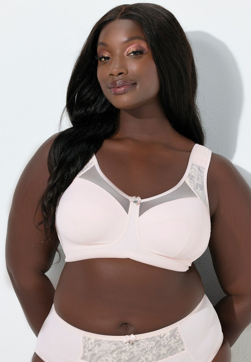 Hellrosa BH mit Netzakzenten, Spitzenverzierungen und dekorativem Knopf. Glatter Stoff, geformte Körbchen und breite Träger für Halt.