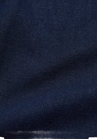 Námorně modrá tkanina s texturovaným vazbováním, která vykazuje jemný, mírně nepravidelný povrch. Materiál umožňuje drapování a lehké aplikace.