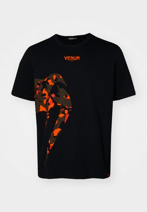 Camiseta de algodón negra con un gran diseño de camuflaje rojo y marrón en el frente y el logo "VENUM" en rojo en el cuello. Mangas cortas.