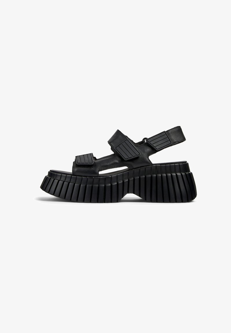 Zwarte platform sandalen met een chunky, ribbelige zool, uitsparingen en verstelbare riemen met gestructureerde accenten voor een veilige pasvorm.