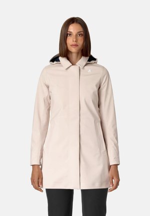 Cappotto impermeabile beige chiaro con colletto alto, chiusura frontale a zip e due tasche laterali. Presenta un cappuccio foderato in blu navy. Tessuto liscio.