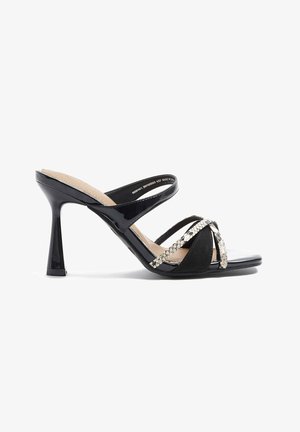 Mule de charol negro con tacón alto, con tres tiras, dos de ellas con textura de piel de serpiente, y un diseño de punta cuadrada.