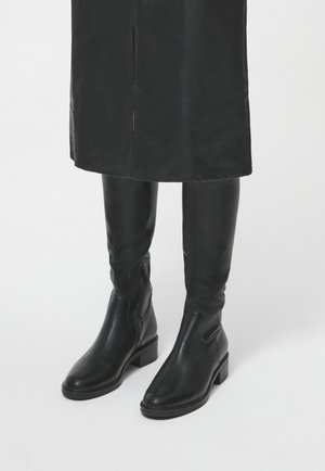 Black knee-high boots made of smooth leather, featuring a block heel and elastic side panels for easy wear. Simple design with no embellishments.