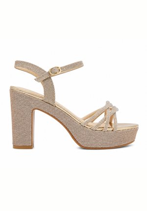 Sandalia plataforma beige con brillo, tacón ancho, tiras cruzadas sobre los dedos y correa ajustable en el tobillo con hebilla dorada.
