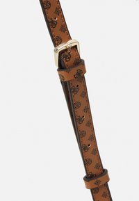 Hnědý kožený pásek s černým vzorem pavoučí sítě, vybavený zlatou kovovou sponou a několika otvory pro úpravu velikosti.