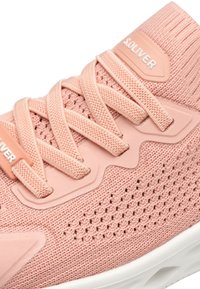 Baskets de sport tricotées roses avec un dessus texturé, des lacets et une semelle en caoutchouc. Présente une étiquette de logo et des motifs découpés pour la ventilation.