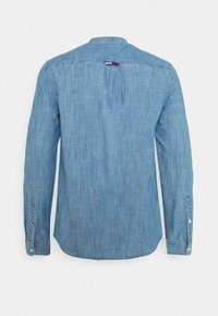 Světle modrá džínová košile na knoflíky, s dlouhými rukávy, rovný lem, s límečkem, záhybem na zádech a značkovou cedulkou u výstřihu.