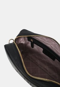 Clutch bag in pelle nera con zip dorata, dotato di una fodera interna a motivo e di una tasca interna con zip per organizzare gli oggetti.