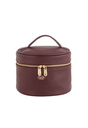 Round burgundy cosmetic bag with textured exterior, gold zipper closure, and a top handle for easy carrying. Elegant logo detail on front.