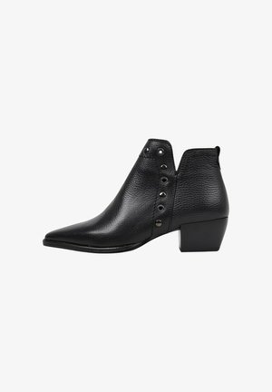 Bottine en cuir noir avec un bout pointu, surface texturée et œillets décoratifs en métal argenté sur le côté. Talon bas.