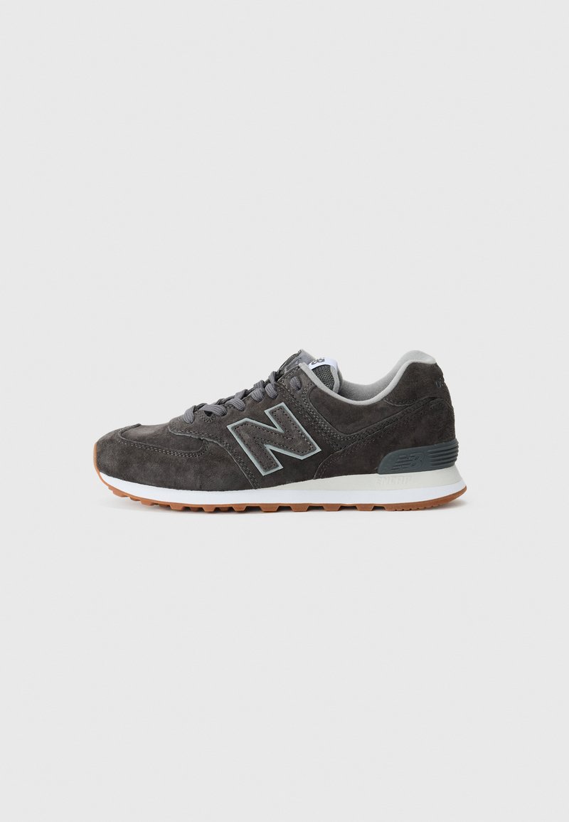 Dark gray suede sneaker with a rubber outsole. Features a light gray "N" logo, gray laces, and a cushioned collar for comfort.