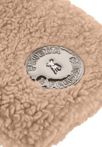 Frieda & Freddies beige fleece stof met een gestructureerd oppervlak, met een ronde glanzende zilveren logo-detail in de hoek.
