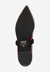 Chaussure à talons hauts en cuir rouge avec un bout pointu, un motif texturé et une sangle noire sur le dessus. Semelle marquée "Fabriqué en Italie", taille 36.