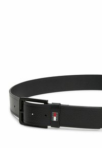 Cinturón de cuero negro con un acabado texturizado, que presenta una hebilla de metal negro mate y un acento de la marca en rojo, blanco y azul.