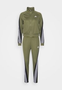 Survêtement vert Adidas avec veste zippée intégrale et pantalon assorti, avec des panneaux noirs et des bandes blanches sur les manches et les jambes.