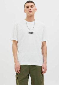White cotton T-shirt with a round neck and short sleeves, featuring a black logo on the chest. Smooth texture, relaxed fit.