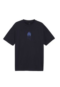 Melnā īsām piedurknēm T-kreklā ar zilo Marseļas futbola kluba logotipu un Puma logotipu centrā uz krūtīm.