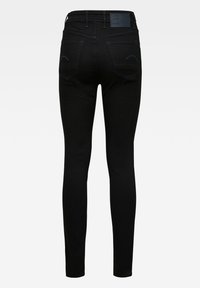 Jeans ajustados de mezclilla negra con una textura suave, con una cintura de altura media, dos bolsillos traseros y sutiles acentos de costura azul.