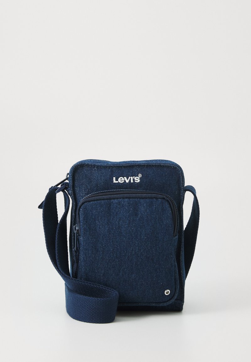 Plavi traper torbica preko ramena s patentnim zatvaračem na prednjoj strani, podesivim remenom i Levi's logom na vrhu. Glatka tekstura i pravokutni oblik.