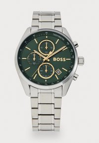 Stainless steel watch with a green dial, gold accents, tachymeter scale, and three sub-dials; rectangular links on the metal bracelet.