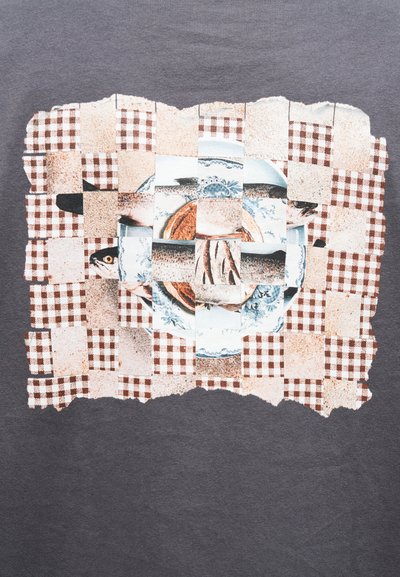 Καρό ύφασμα με υφαντές λωρίδες που δείχνουν ένα ψάρι σε πιάτο πάνω σε καφέ και λευκό καρό τραπεζομάντηλο.