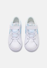 Baltie Nike kedas ar gaiši ziliem akcentiem, kam ir gluda sintētiska virsma, auklu aizdare un siksna drošai fiksācijai. Noapaļota purngala forma.