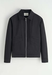 Veste noire avec un col structuré, fermeture éclair sur le devant et deux poches en biais. Tissu lisse avec un design moderne et minimaliste.