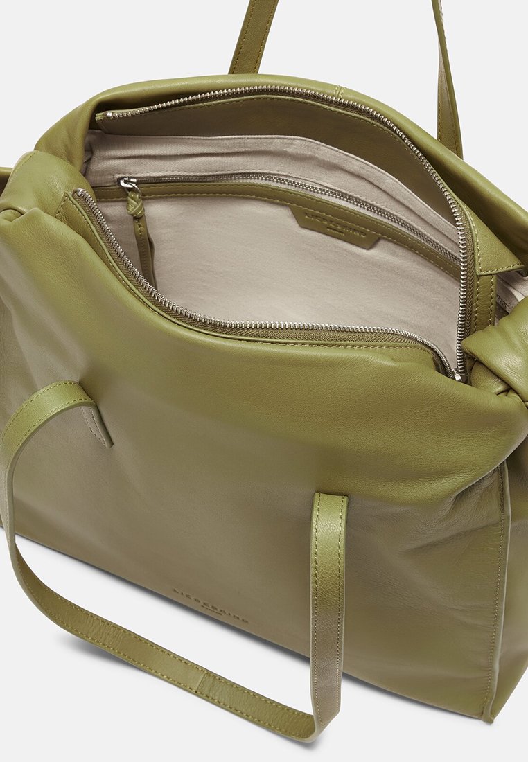 Duża zielona skórzana torba o gładkiej teksturze, z zamknięciem na zamek błyskawiczny i przegrodami wewnętrznymi. Mocne uchwyty do noszenia.