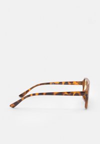 Lunettes de soleil en écaille de tortue avec des montures épaisses et rectangulaires et des branches lisses et courbées. Fini texturé avec un subtil motif détaillé.
