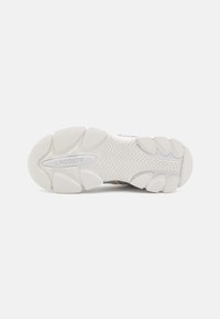 Lacoste sneaker outsole, textured white rubber with deep tread patterns, featuring a central logo and curved design details.