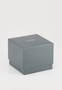 Gesloten donkergrijze Timex-doos met een licht gestructureerd oppervlak op een lichte achtergrond.