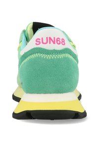 Scarpa sportiva in suede verde con un tassello bianco sul tallone recante la scritta rosa "SUN68", suola in gomma gialla e nera, e accenti blu.