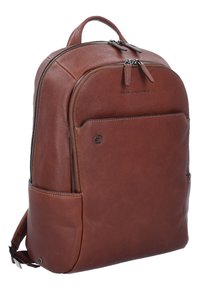 Sac à dos en cuir marron avec une texture lisse, fermeture à double zip et poche latérale. Présente un détail de logo subtil à l'avant.