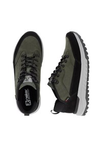 Green hiking shoes with a mix of suede and textile materials, featuring black accents, thick grip soles, and lace-up design with reinforced eyelets.