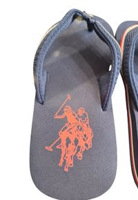 Infradito navy con una fascetta testurizzata, che presenta una grafica di un giocatore di polo arancione sul plantare. Suola in gomma con dettagli rossi.