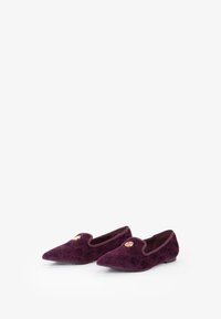 Mocassini in velluto bordeaux con punta affusolata, decorati con hardware dorato sulla parte anteriore e una superficie liscia. Design a profilo basso e facile da indossare.