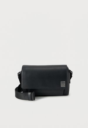 Μαύρη δερμάτινη τσάντα χιαστί με ορθογώνιο σχήμα, υφή επιφάνειας, κλείσιμο με καπάκι, ρυθμιζόμενο λουρί και λογότυπο στο μπροστινό μέρος.