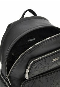 Zaino in pelle nera con più scomparti con cerniera, superficie strutturata e interno con motivo a logo ripetuto.
