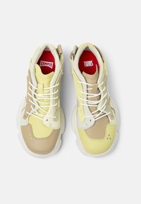 Sneakers with a yellow, beige, and white multi-material upper; chunky sole; features laces and branding on insoles in red.