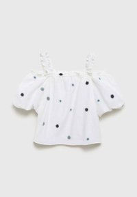 Blusa bianca con spalle scoperte e spalline arricciate, decorata con ricami floreali blu e neri su un tessuto leggero.