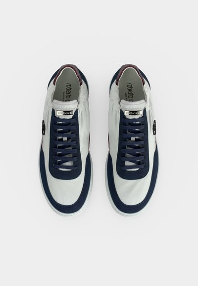 Paire de baskets blanches avec bordure et lacets bleu marine, accents bordeaux au talon, vues de dessus sur fond blanc.