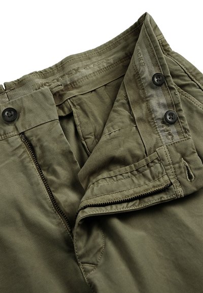 Spodnie w kolorze khaki wykonane z materiału bawełnianego, z rozporkiem na zamek i zapięciem na guzik oraz przeszywanymi szwami. Tkanina ma gładką fakturę z delikatnymi wariacjami.