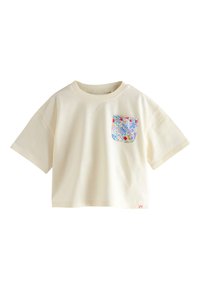 Cremefarbenes T-Shirt mit kurzen Ärmeln und einer bunten Blumenmuster-Tasche. Hergestellt aus weichem Stoff, mit rundem Ausschnitt und lockerem Schnitt.