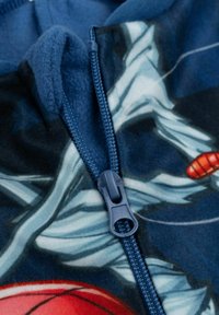 Felpa con cappuccio in pile con zip blu, caratterizzata da una base blu scuro e un design grafico colorato con schemi di accenti rossi e bianchi.