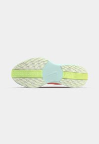 Semelle de chaussure Nike avec un motif texturé, une semelle intermédiaire bleu clair et des accents jaunes. Le dessous présente des détails complexes pour une meilleure adhérence.