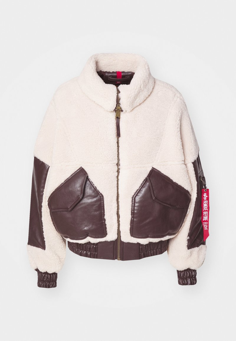 Bicolor Bomberjacke mit einem cremefarbenen, flauschigen Obermaterial, braunen Lederelementen, Reißverschluss, großen Taschen sowie einem elastischen Bund und Ärmeln.
