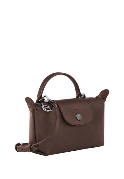 Small brown leather handbag with top handle, flap closure, silver button, and detachable shoulder strap on white background.