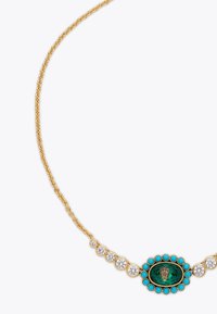 Collana in oro con un pendente centrale ovale, dotato di una pietra verde, circondato da perline turchesi e cristalli trasparenti.